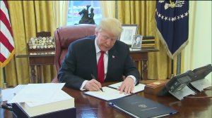 President Trump prepares to sign the Republican tax cut bill on Dec. 22, 2017. (Credit: KTLA)