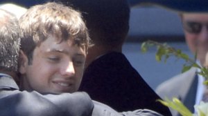 Burke Ramsey is embraced by his father at the grave of JonBenet Ramsey after a funeral service for his mother Patsy Ramsey June 29, 2006 in Marietta, Georgia. (Credit: Barry Williams/Getty Images)