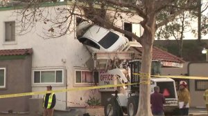 A car remains lodged inside the second floor of a Santa Ana dentist office after the driver crashed into the building on Jan. 14, 2018. (Credit: KTLA)