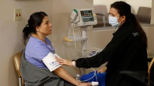 Marenna Bielman, right, takes Angelica Lara's blood pressure as she is treated for flu-like symptoms at St. Joseph Hospital in Orange. (Credit: Allen J. Schaben / Los Angeles Times)