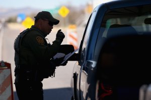 A U.S. Border Patrol agent speaks to a driver at a checkpoint from Mexico into the United States on Feb. 26, 2013, north of Nogales, Arizona. (Credit: John Moore / Getty Images)