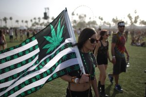 A woman carries a flag bearing marijuana leaves at the Coachella Valley Music & Arts Festival in Indio on April 12, 2014. (Credit: David McNew / AFP / Getty Images)