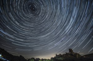 In this composite image, satellites, planes and comets transit across the night sky under stars that appear to rotate above Corfe Castle in the United Kingdom on Aug. 12, 2016. (Credit: Dan Kitwood / Getty Images)
