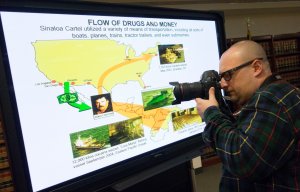 A photographer takes photos of the display used at the press conference discussing the extradition of Joaquin "El Chapo" Guzman on Jan. 20, 2017, in New York.(Credit: Don Emmert / AFP / Getty Images)