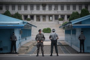In a photo taken on August 2, 2017, South Korean soldiers stand guard before North Korea's Panmon Hall (rear C) and the military demarcation line separating North and South Korea, at Panmunjom, in the Joint Security Area (JSA) of the Demilitarized Zone (DMZ).. (Credit: ED JONES/AFP/Getty Images)