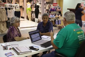 Isabel Diaz Tinoco, left, and Jose Luis Tinoco speak with Otto Hernandez, an insurance agent from Sunshine Life and Health Advisors, as they shop for insurance under the Affordable Care Act at a store setup in the Mall of Americas in Miami, Florida, on Nov. 1, 2017. (Credit: Joe Raedle / Getty Images)