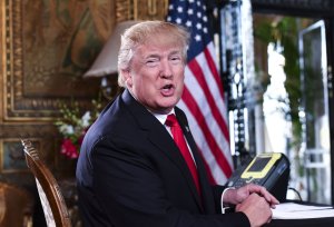 U.S. President Donald J. Trump speaks to the media before participating in a video teleconference calls with military members on Christmas Eve in Palm Beach, Florida on December 24, 2017. (Credit: NICHOLAS KAMM/AFP/Getty Images)