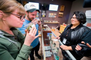 Tourists Laura Torgerson and Ryan Sheehan, visiting from Arizona, smell cannabis buds at the Green Pearl Organics dispensary in Desert Hot Springs on the first day of legal recreational marijuana sales in California, Jan. 1, 2018. (Credit: Robyn Beck / AFP / Getty Images)