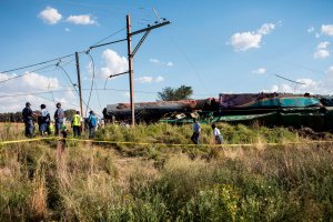 Members of the South African Police Service and Passenger Rail Agency South Africa look at a derailed train locomotive after an accident near Kroonstad in the Free State Province on Jan. 4, 2018. (Credit: Wikus de Wet/AFP/Getty Images)