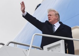 Donald Trump waves as he boards Air Force One at Joint Base Andrews, Maryland on Jan. 12, 2018, for a weekend trip to Mar-a-Lago. (Credit: Nicholas Kamm /AFP/Getty Images)