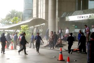 This photo received from Amailia Putri Hasniawati via WhatsApp shows people running for cover at the entrance of Indonesia's stock exchange in Jakarta after an internal balcony collapsed on Jan. 15, 2018.