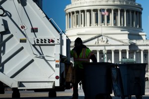A trash collector removes garbage from Capitol Hill just as the government begins a shutdown on Jan. 20, 2018. (Credit: Brendan Smialowski / AFP / Getty Images)