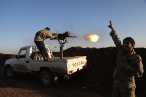 Turkish-backed fighters from the Free Syrian Army stand in the Tal Malid area, north of Aleppo, as they fire towards Kurdish People's Protection Units (YPG) positions in the village of Um al-Hosh on Jan. 20, 2018. (Credit: Nazeer Al-Khatib / AFP / Getty Images)