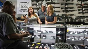 Store managers Jamie Taflinger, left, and Kendyll Murray show customer Cornell Hall, of Highland, Calif., different types of ammunition at the Get Loaded gun store in Grand Terrace in 2016. (Credit: Gina Ferazzi / Los Angeles Times)