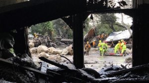 A swollen creek sent debris and mud flows racing along the 300 block of Hot Springs Road in Montecito following heavy rain Tuesday morning. (Credit: Mike Eliason / Santa Barbara County Fire Department)