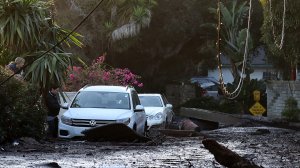 A resident looks into her car that sits in mud and debris from a mudslide on Jan. 11, 2018, in Montecito. (Credit: Justin Sullivan/Getty Images)