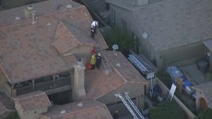 Authorities respond to a home on which a skydiver landed in Perris on Jan. 22, 2018. (Credit: KTLA)