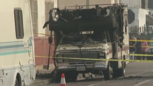 Spectators gather at the scene of a fatal RV fire in Wilmington on Jan 2, 2018. (Credit: KTLA)