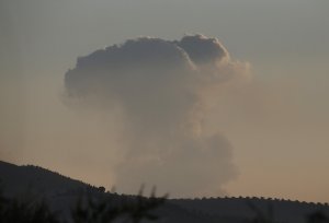 A plume of smoke rises Saturday from inside Syria, as seen from outside the border town of Kilis, Turkey. (Credit: Lefteris Pitarkis / AP via CNN)