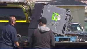 Crews retrieve an ATM from a dump truck in Lynwood on Feb. 25, 2018. (Credit: KTLA)