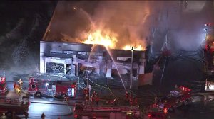 Firefighters are seen battling a blaze at a vacant strip mall in South L.A. on Feb. 13, 2018. (Credit: KTLA)