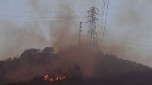 Fire burns near power lines at the Thomas Fire, Dec. 16, 2017, in Montecito. (Credit: ROBYN BECK/AFP/Getty Images)