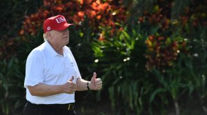 Donald Trump holds two thumbs up while meeting with service members of the United States Coast Guard to play golf at Trump International Golf Course in Mar-a-Lago, Florida on Dec. 29, 2017. (Credit: NICHOLAS KAMM/AFP/Getty Images)