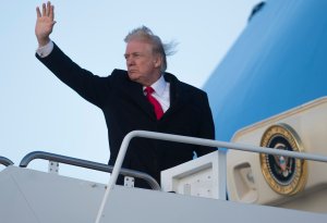 President Donald Trump waves from Air Force One prior to departure from Joint Base Andrews in Maryland, Feb. 2, 2018, as he travels to Mar-a-Lago for the weekend. (Credit: Saul Loeb / AFP / Getty Images)