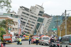 Rescue and emergency workers block off a street where a building came off its foundation, the morning after a 6.4 magnitude quake hit the eastern Taiwanese city of Hualien, on February 7, 2018. (Credit: PAUL YANG/AFP/Getty Images)