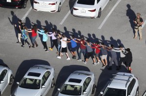 People are brought out of the Marjory Stoneman Douglas High School after a shooting at the school that reportedly killed and injured multiple people on February 14, 2018 in Parkland, Florida. (Credit: Joe Raedle/Getty Images)