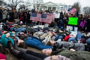 Demonstrators lie on the ground a "lie-in" demonstration supporting gun control reform near the White House on Feb. 19, 2018. (Credit: Zach Gibson / Getty Images)
