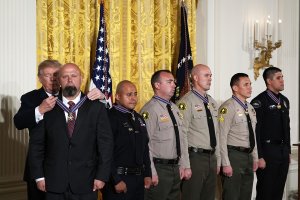 (Left to right) Donald Trump presents the Public Safety Medal of Valor to San Bernardino County District Attorney's Office Investigator Chad Johnson, San Bernardino Police Department Detective Brian Olvera, San Bernardino County Sheriff's Department Deputy Shaun Wallen, Detective Bruce Southworth, Corporal Rafael Ixco and Redlands Police Department Officer Nicholas Koahou during an award ceremony at the East Room of the White House on Feb. 20, 2018 in Washington, DC. (Credit: Alex Wong/Getty Images)