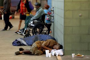 A man sleeps on the sidewalk in front of the Union Rescue Mission in the skid row neighborhood of Los Angeles. (Credit: Francine Orr / Los Angeles Times)