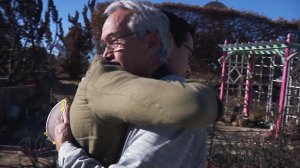 Ansen "Tony" Roberts and Zach Garcia embrace at the site of Roberts' burned-out home that was destroyed in the Thomas Fire. (Credit: KTLA)