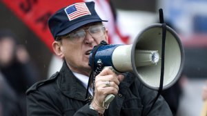 Arthur Jones shouts into a bullhorn during a protest at the dedication ceremony for the Illinois Holocaust Museum and Education Center in Skokie, Illinois, in April 2009. (Credit: Tannen Maury/EPA/REX/Shutterstock)