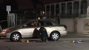 Investigators look through the scene in Chino where a woman was found stabbed and a man later was found dead nearby on March 24, 2018. (Credit: KTLA)