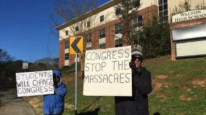 Two parents of students who attend Walton High School in suburban Atlanta protest outside the school as part of nationwide protests against gun violence and in support of school safety. (Credit: CNN)