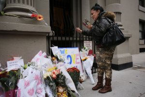 Angel Colone prays in front of the building where two children were stabbed to death allegedly by their nanny in a family's Upper West Side apartment on Oct. 26, 2012, in New York City. (Credit: Spencer Platt / Getty Images)