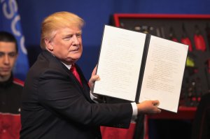 President Donald Trump signs an executive order to try to bring jobs back to American workers and revamp the H-1B visa guest worker program during a visit to the headquarters of tool manufacturer Snap-On on April 18, 2017 in Kenosha, Wisconsin. (Credit: Scott Olson/Getty Images)