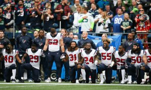 Members of the Houston Texans stand and kneel before the game against the Seattle Seahawks at CenturyLink Field on October 29, 2017 in Seattle. (Credit: Otto Greule Jr/Getty Images)