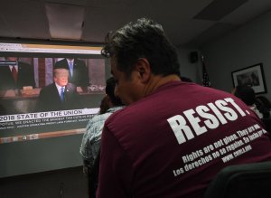 DACA recipients and their supporters watch President Donald Trump during a State of the Union party at the Coalition for Humane Immigrant Rights and the California Dream Network offices in Los Angeles on Jan. 30, 2018. (Credit: MARK RALSTON/AFP/Getty Images)