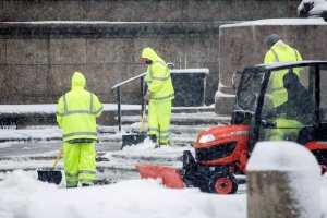 Workers clear snow from the walkway around the Boston Public Library in Copley Square as Winter Storm Skylar bears down on March 13, 2018. (Credit: Scott Eisen/Getty Images)