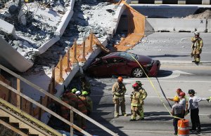 Miami-Dade Fire Rescue Department personnel and other rescue units work at the scene where a pedestrian bridge collapsed a few days after it was built over southwest Eighth Street at Florida International University on March 15, 2018, in Miami. (Credit: Joe Raedle/Getty Images)