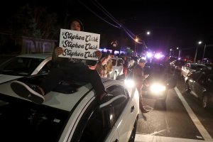 A Black Lives Matter protester holds a sign as he sits on his car blocking an intersection during a demonstration on March 23, 2018 in Sacramento. (Credit: Justin Sullivan/Getty Images)