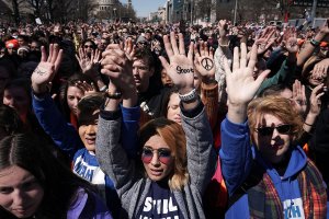 Protesters, including Daisy Hernandez of Virginia (3rd L) and Hunter Nguyen of Maryland (2nd L), hold their hands up as they participate in the March for Our Lives rally in Washington, D.C. on March 24, 2018. (Credit: Alex Wong/Getty Images)