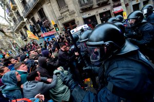 Protesters scuffle with police blocking the road leading to the central government offices at a demonstration in Barcelona on March 25, 2018 after Catalonia's former president was arrested by German police. (Credit: LLUIS GENE/AFP/Getty Images)