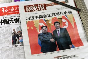 The front pages of Chinese evening newspapers, showing images of China's President Xi Jinping with North Korean leader Kim Jong Un, are displayed at a newspaper stand in Beijing on March 28, 2018. (Credit: FRED DUFOUR/AFP/Getty Images)