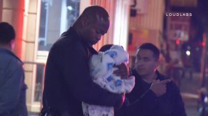 Officer Frazier of the LAPD is seen holding a baby he managed to resuscitate after police responded to a domestic dispute call in L.A.'s Westlake district on March 4, 2018. (Credit: Loudlabs)