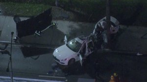 A Maserati appears to be split in half and badly damaged after the driver crashed into a tree in Long Beach on March 16, 2018. (Credit: KTLA)