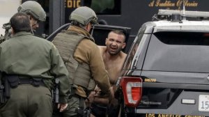 L.A. County sheriff's deputies escort Isaias De Jesus Valencia, suspected of fatally shooting a Pomona police officer, to a waiting car on Saturday. (Credit: Irfan Khan / Los Angeles Times)